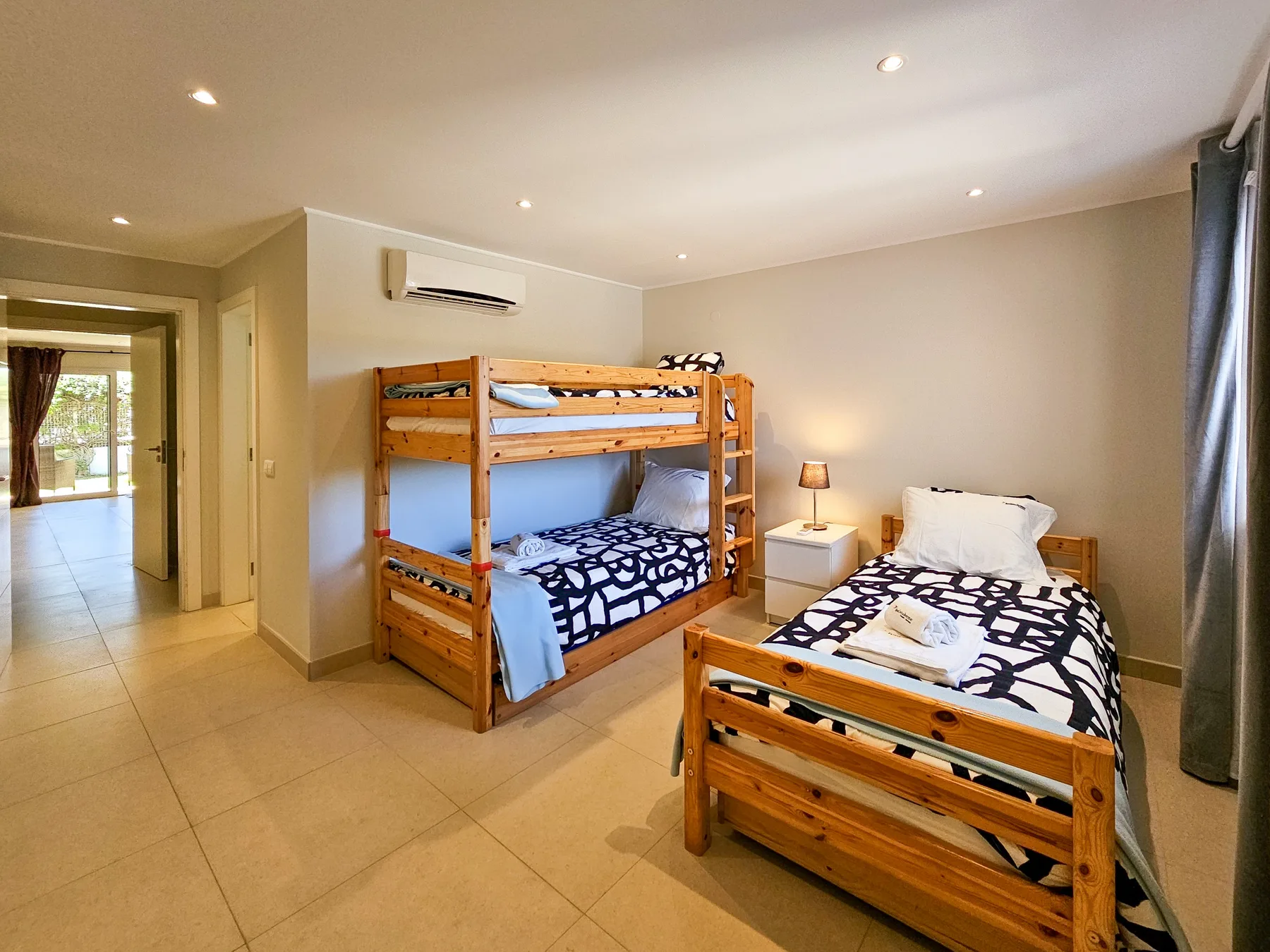 Un dormitorio con literas de madera y una cama individual aparte.
