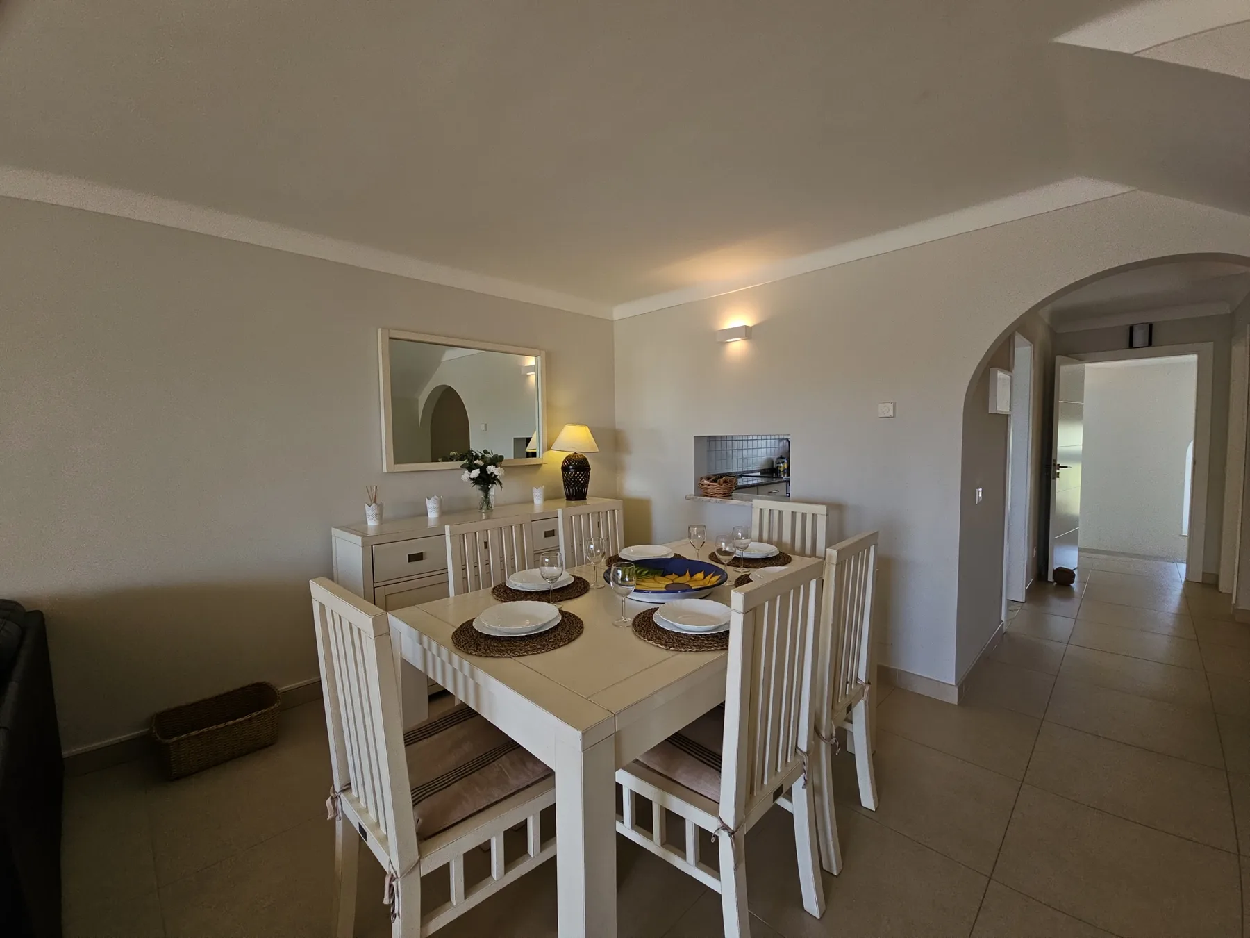 Un comedor con la mesa puesta y un aparador junto a la pared.