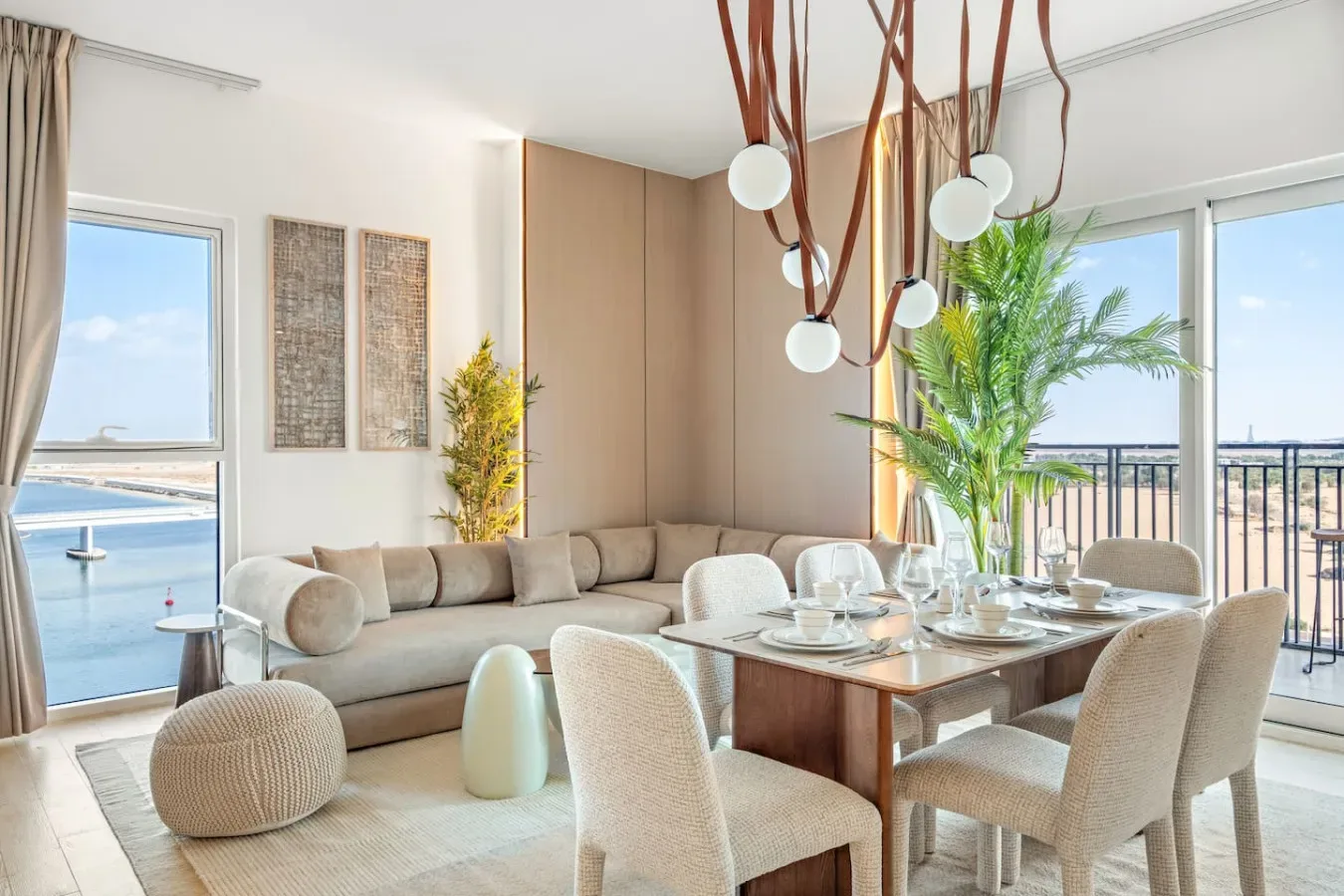 Una luminosa sala de estar y comedor con sofá seccional y mesa puesta.