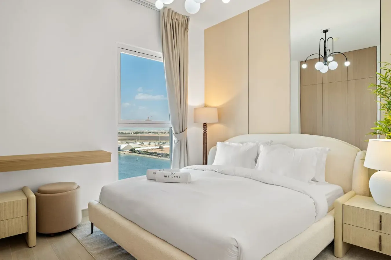 Un dormitorio luminoso con una cama bien arreglada y una ventana con vistas al agua.