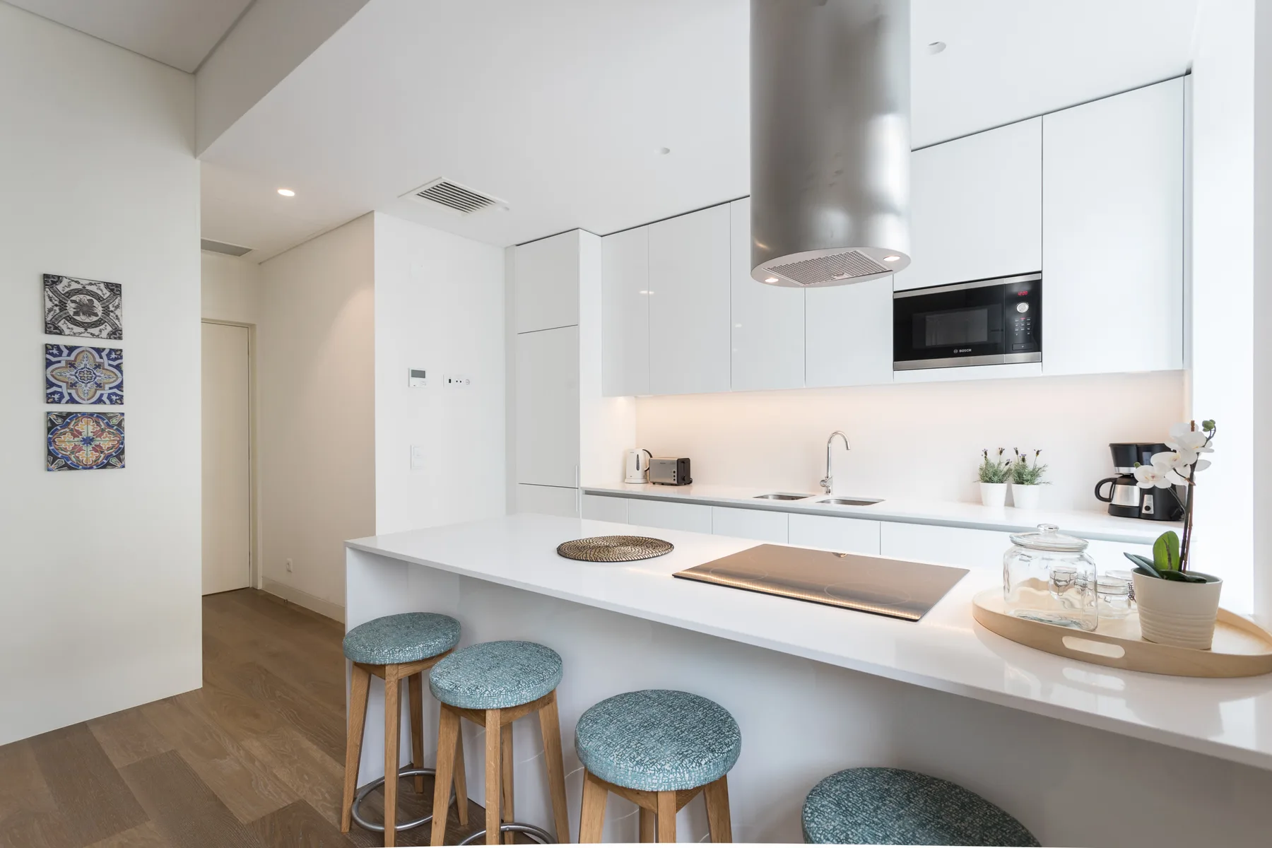 Una cocina moderna y luminosa con una isla blanca y electrodomésticos integrados.