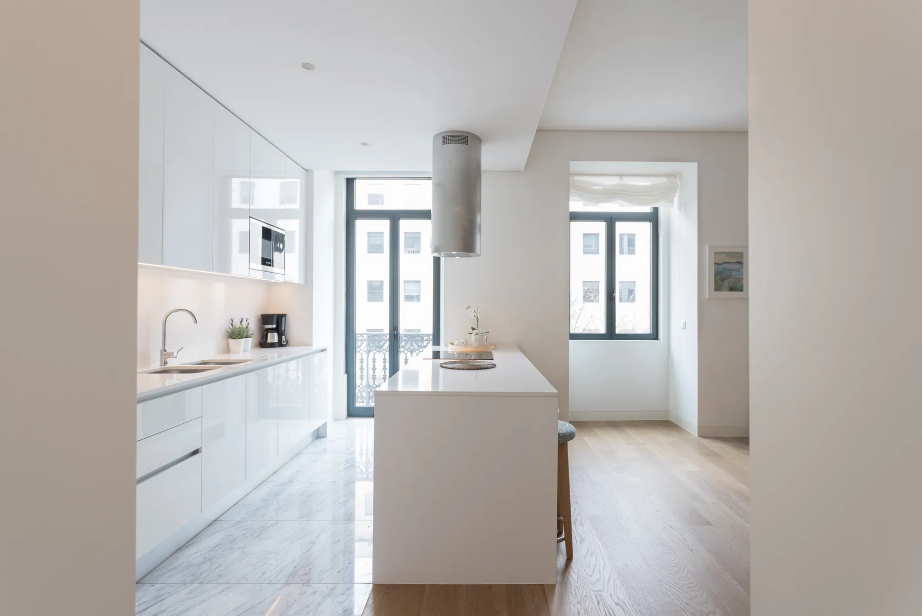 Una cocina moderna y luminosa con gabinetes blancos y una isla central.