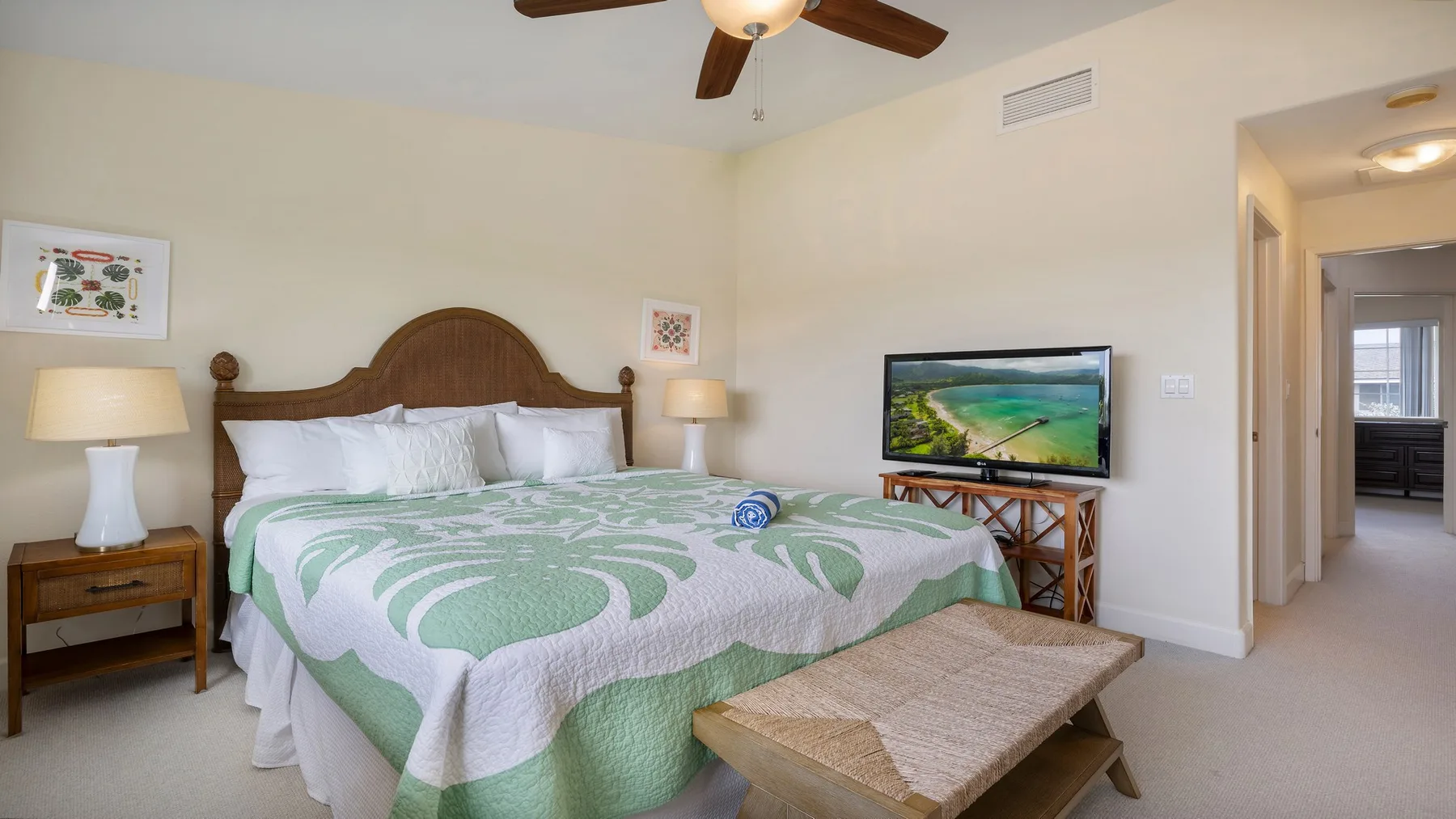 Un dormitorio con una cama grande vestida con ropa de cama estampada en verde y blanco.