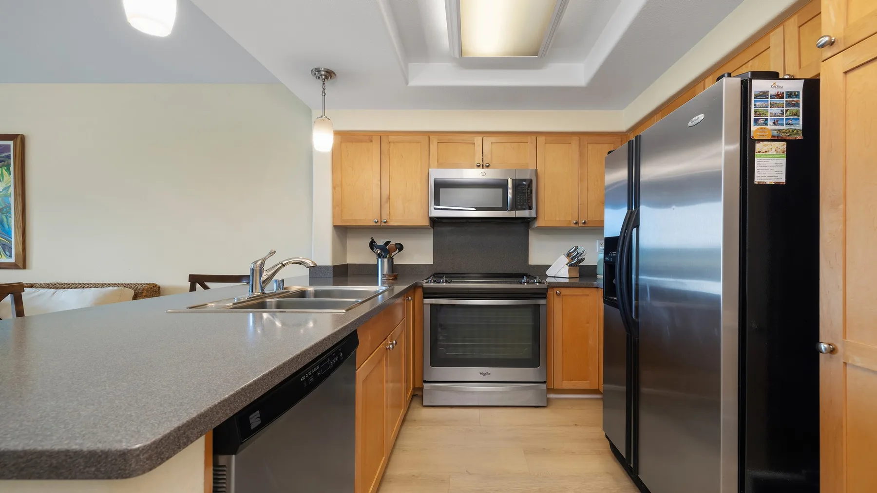 Una cocina con gabinetes de madera, una encimera y electrodomésticos de acero inoxidable.
