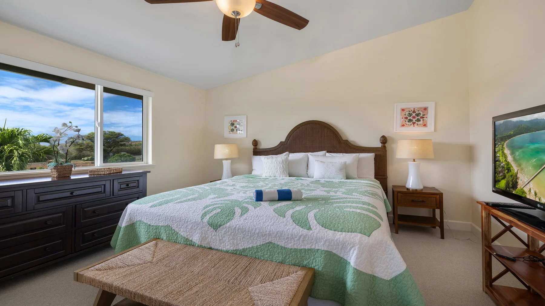 Un dormitorio con una cama cubierta con una colcha estampada verde y blanca.
