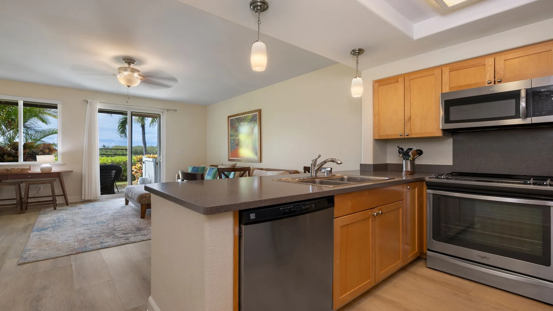 Una cocina abierta con una isla central y una sala de estar contigua.