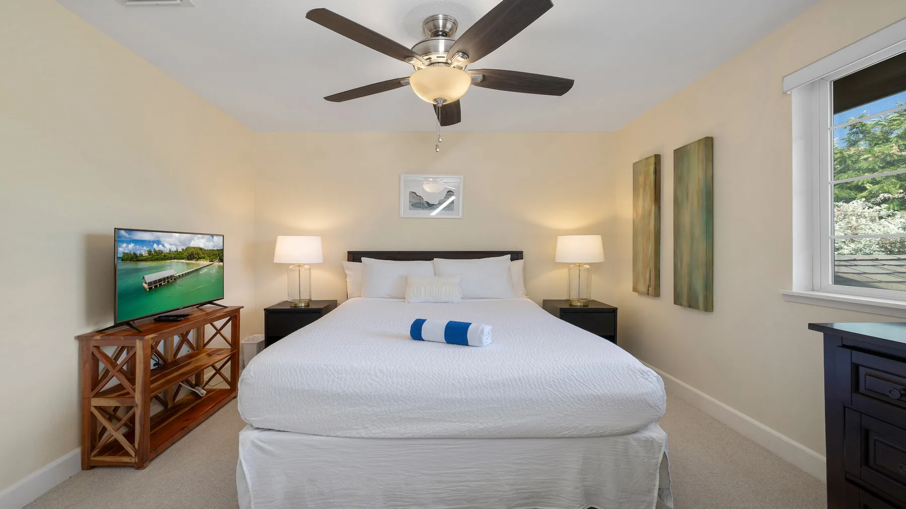 Un dormitorio con una cama tendida, lámparas de noche y un ventilador de techo.