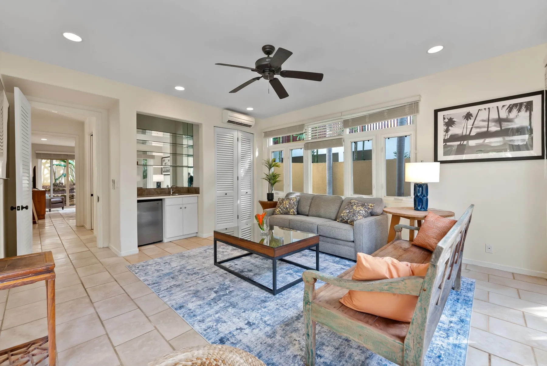 A living room with seating around a coffee table and large windows.