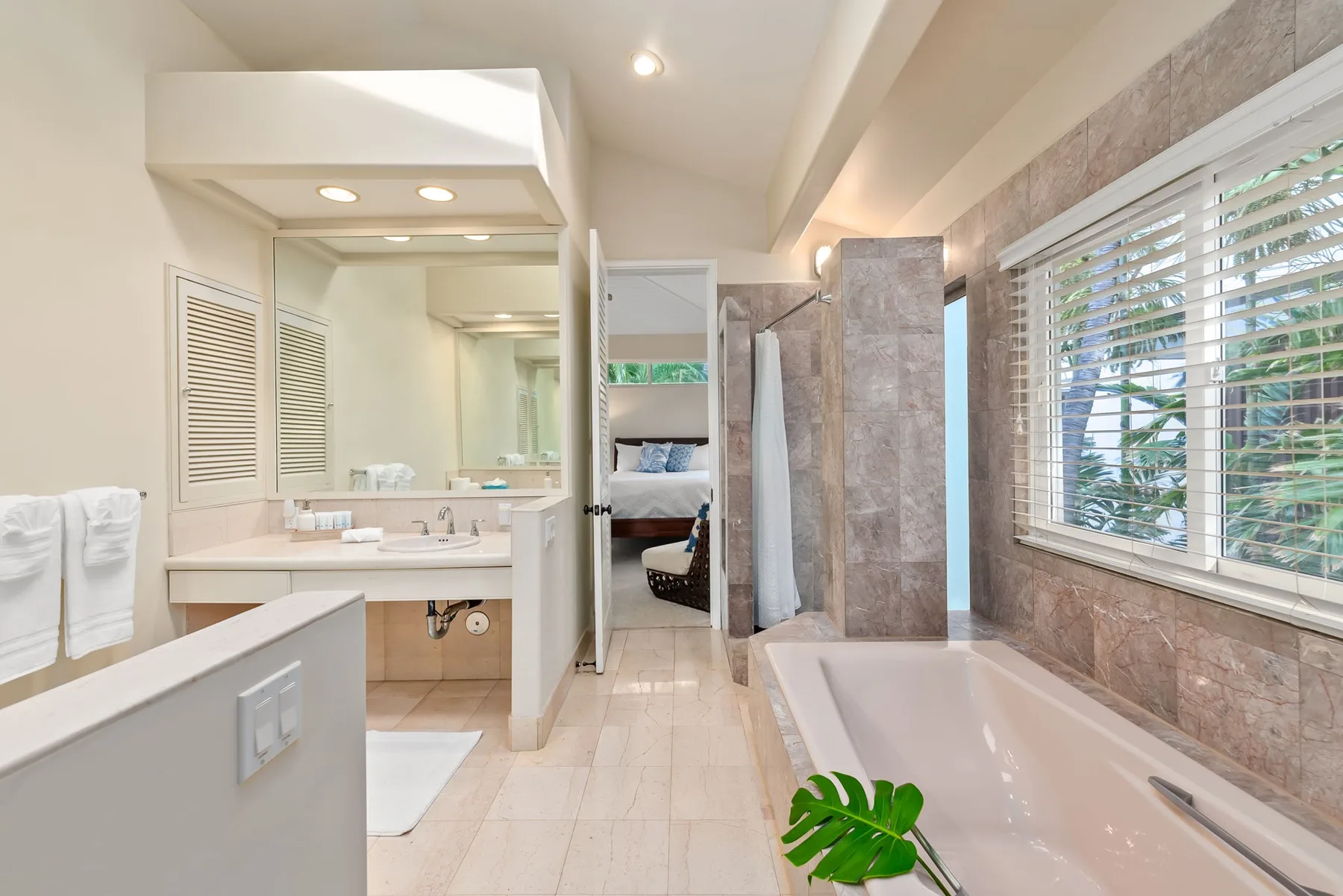 A bathroom with a bathtub beside a large window.