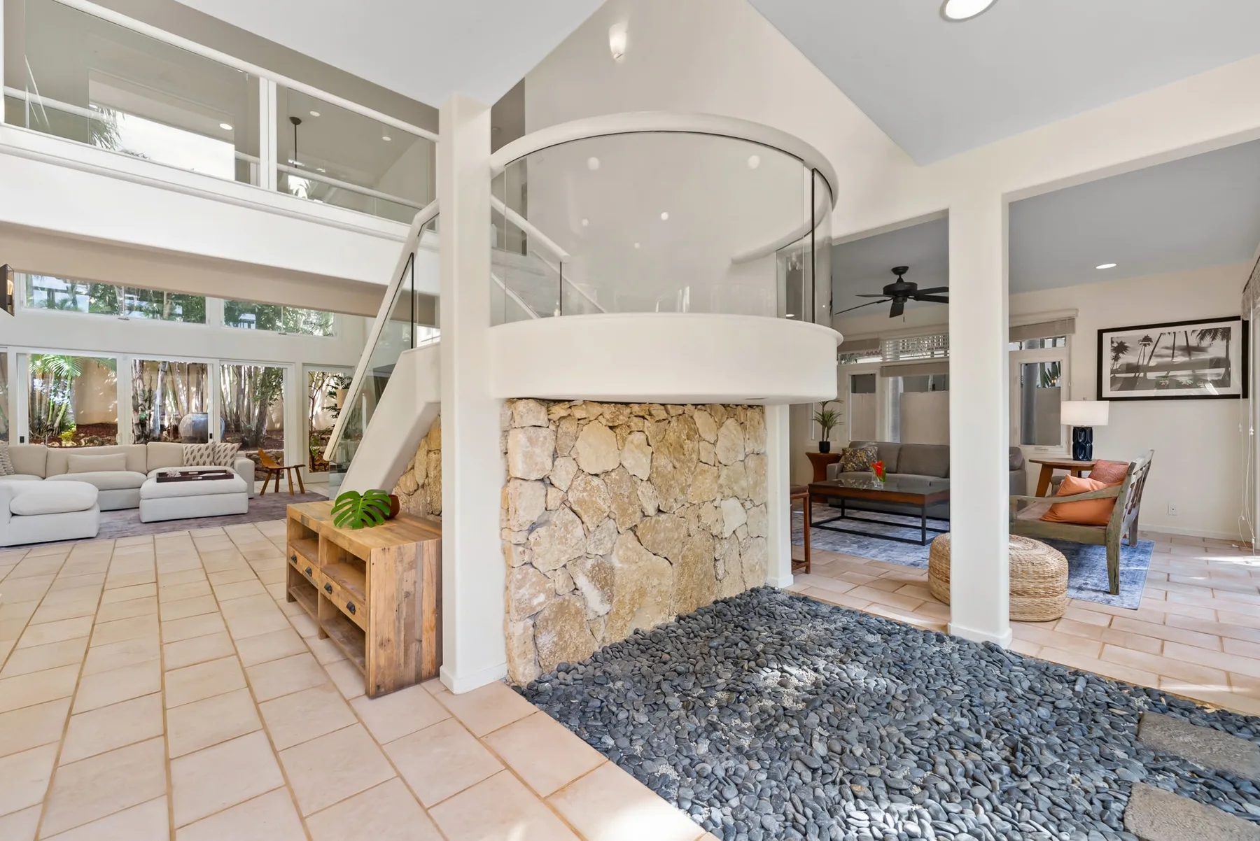 An open living area with a curved raised feature above a stone wall and tiled floors.