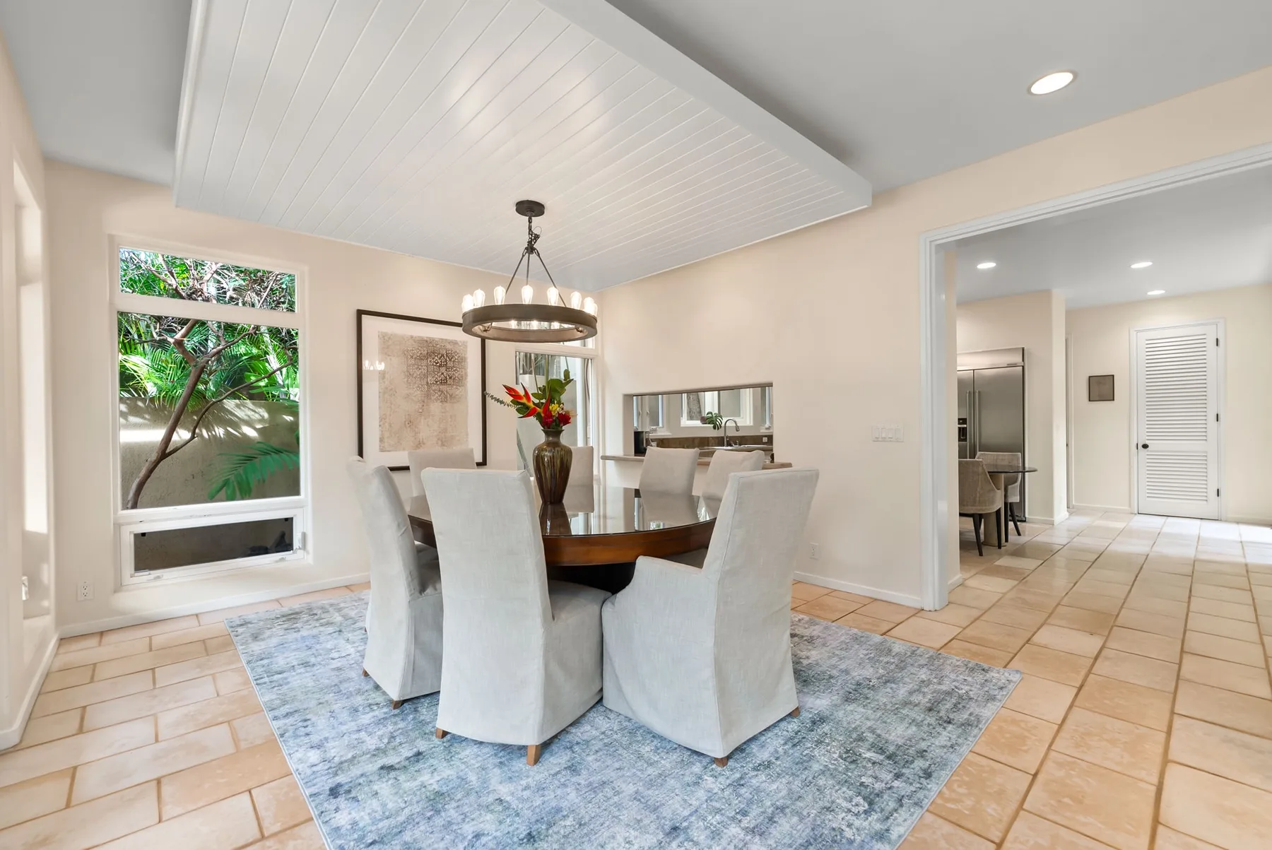 A dining area with a table and upholstered seating on a blue rug.