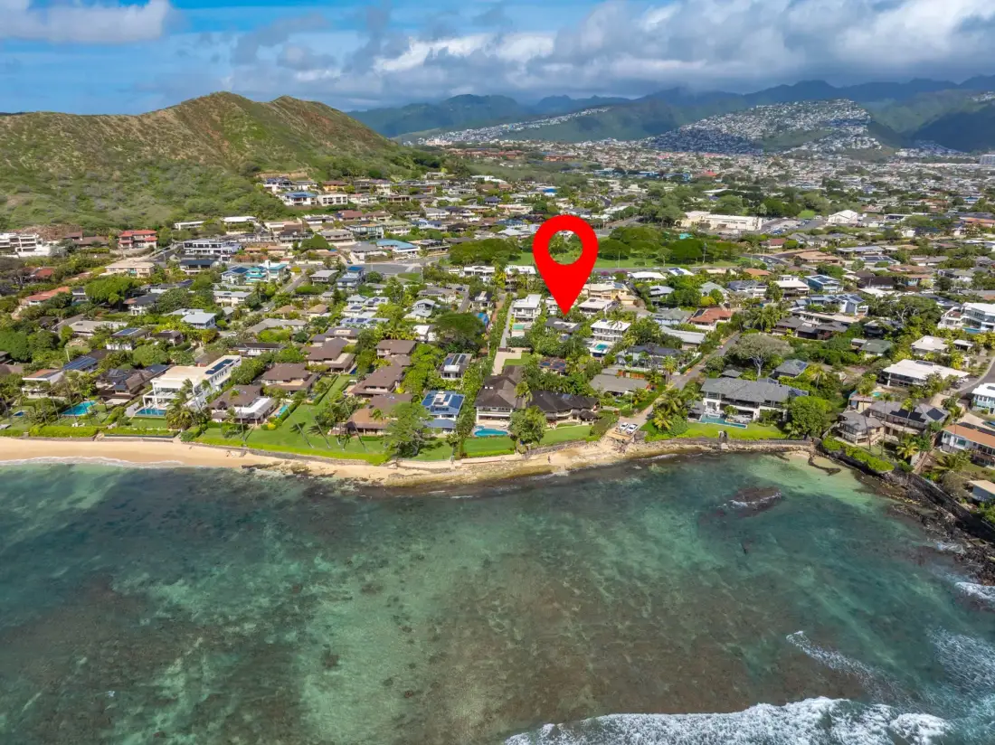 An aerial view of a coastal neighborhood with homes along the shoreline.