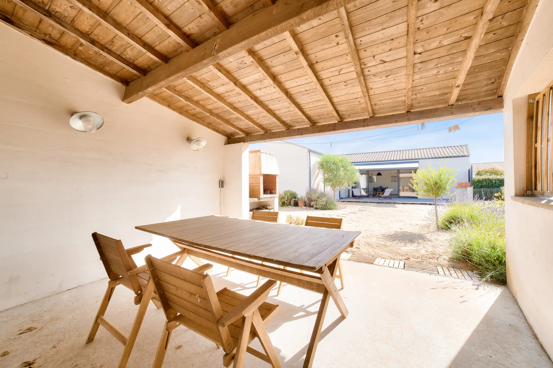 A covered outdoor dining area opens onto a sunny courtyard.
