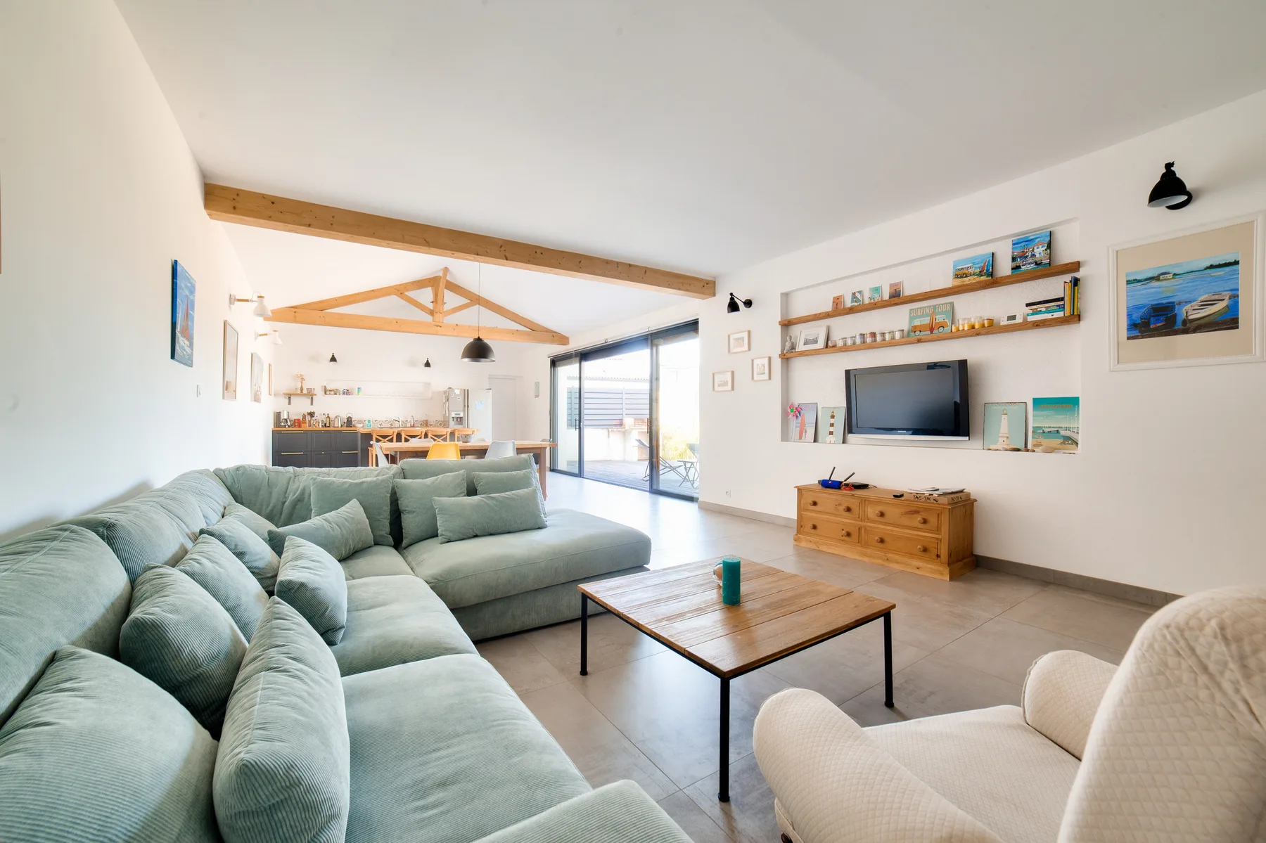 Living room with seating, a coffee table, and a wall-mounted television.