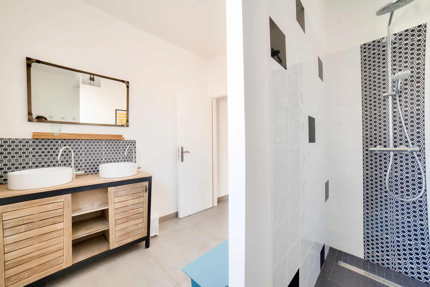 A bathroom with a double vanity and a tiled shower.