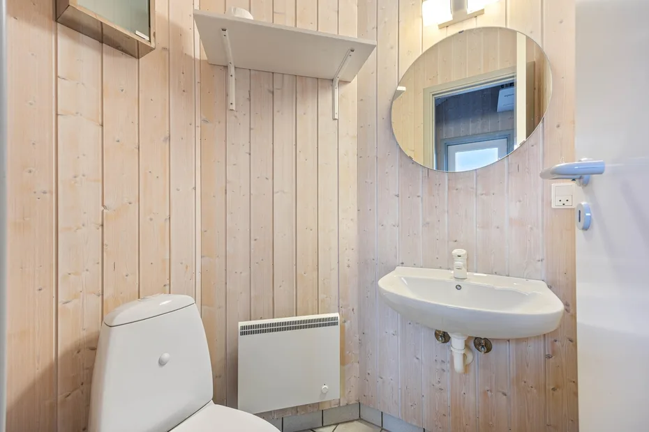 Un baño compacto con lavabo y espejo en la pared.