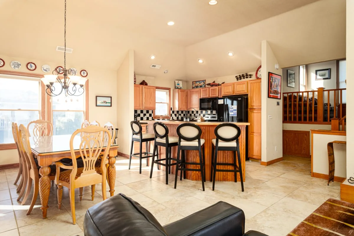 Una cocina abierta y zona de comedor con barra y mesa de comedor.