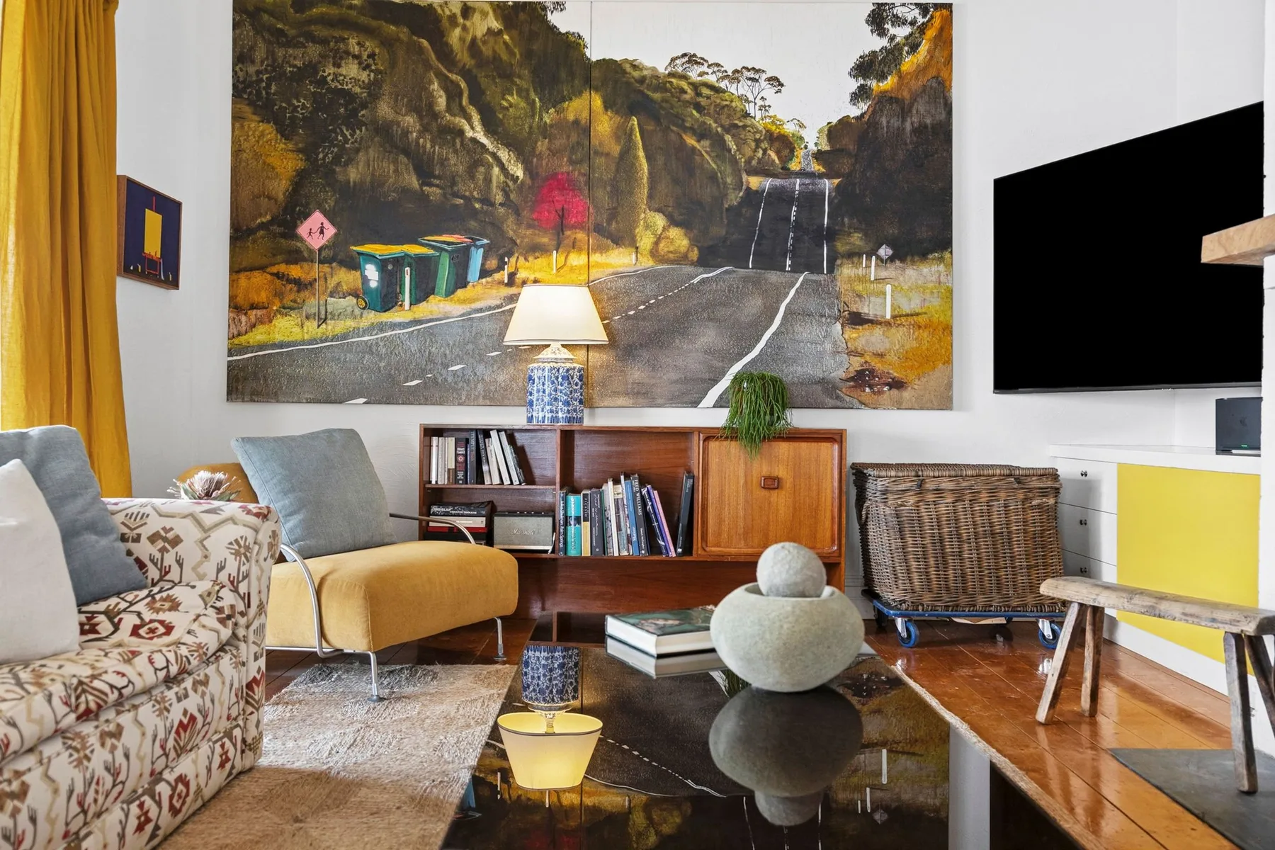 Una sala de estar con distintos asientos alrededor de una mesa de centro y una obra grande.