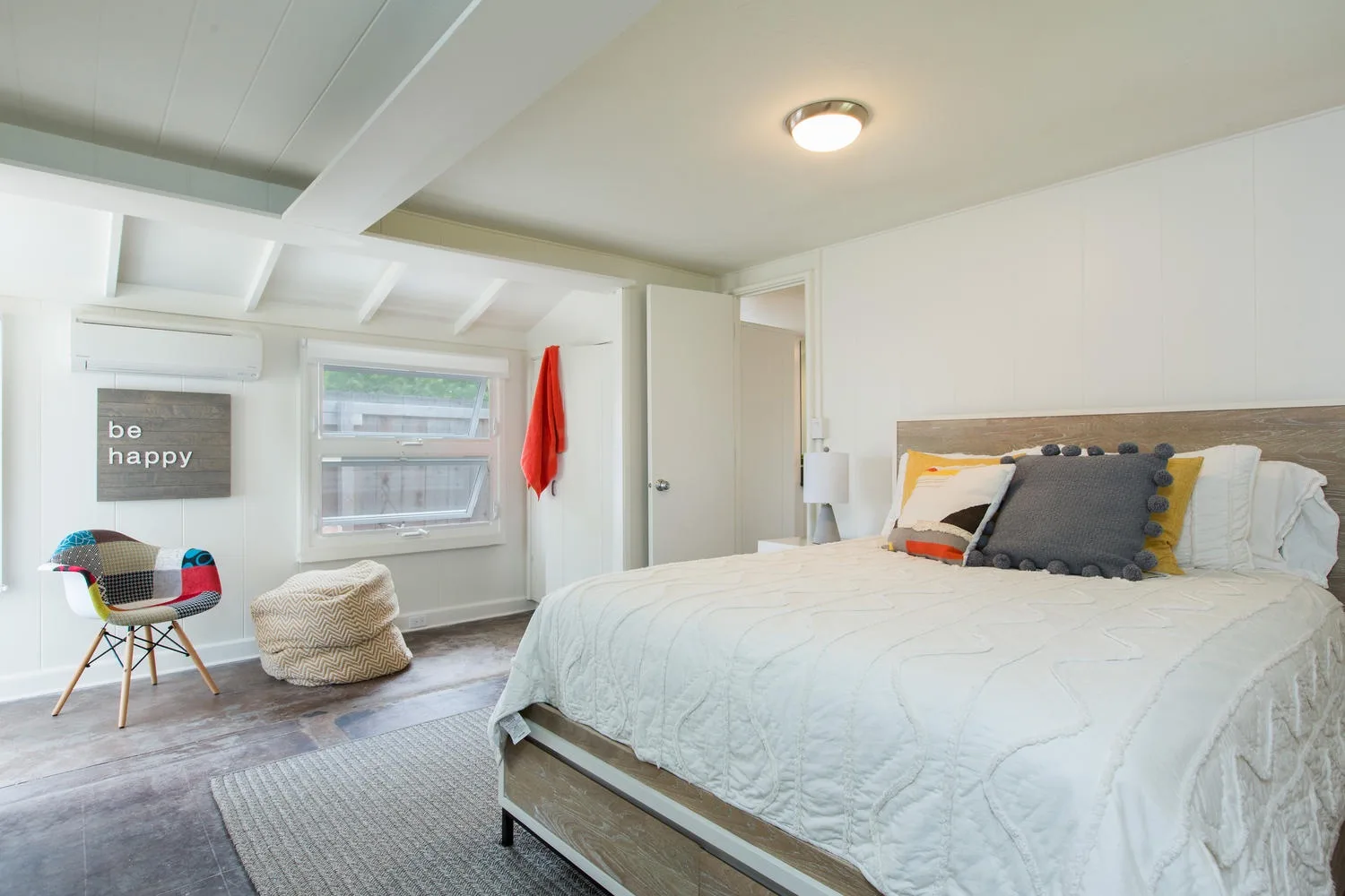 Un dormitorio luminoso con una cama grande y una ventana.