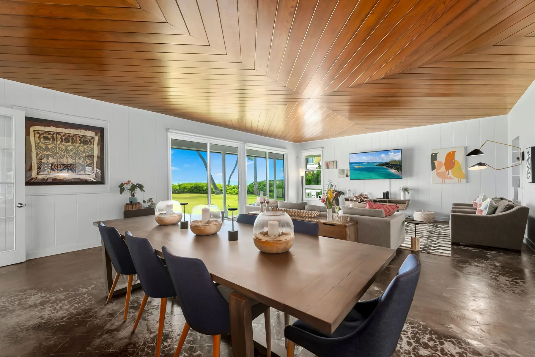 Un luminoso salón-comedor de planta abierta con una mesa grande y vistas al jardín.