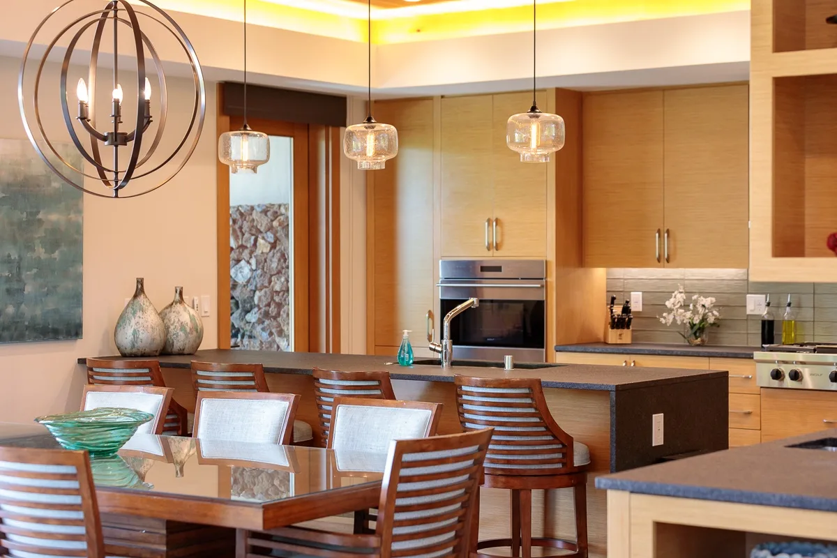Un comedor con una mesa de vidrio junto a una cocina moderna.