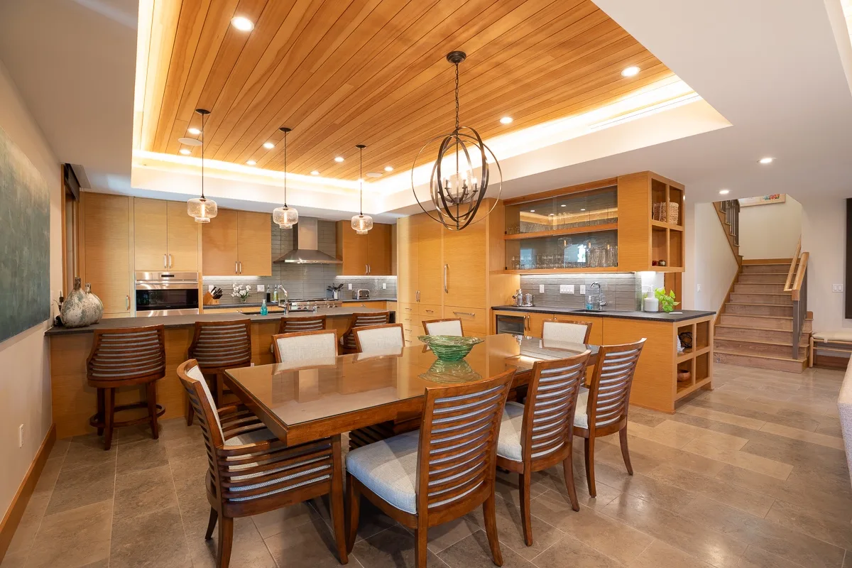 Cocina y comedor de concepto abierto con una mesa grande de madera e isla.