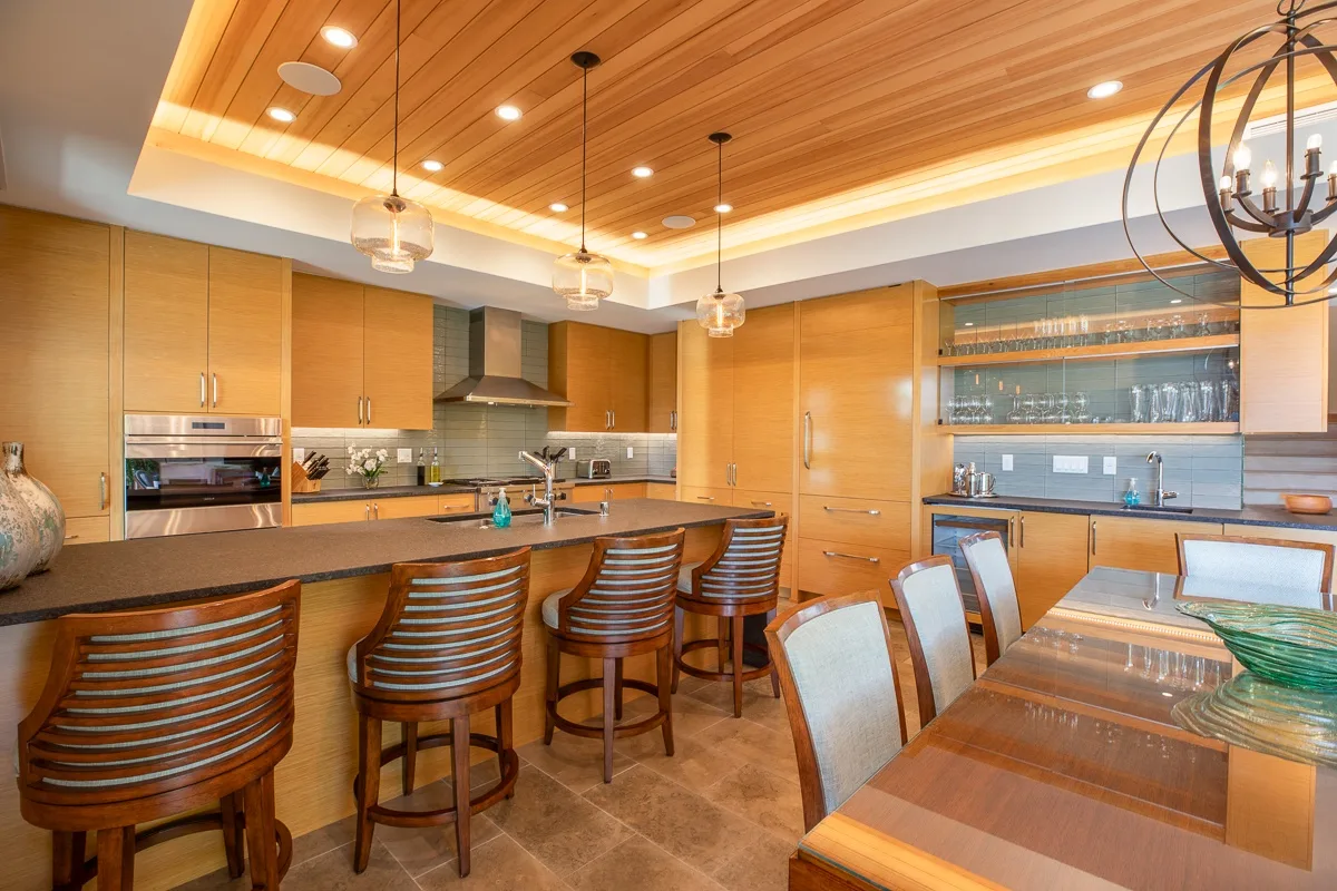 Una amplia cocina y comedor con una barra larga y gabinetes de madera.