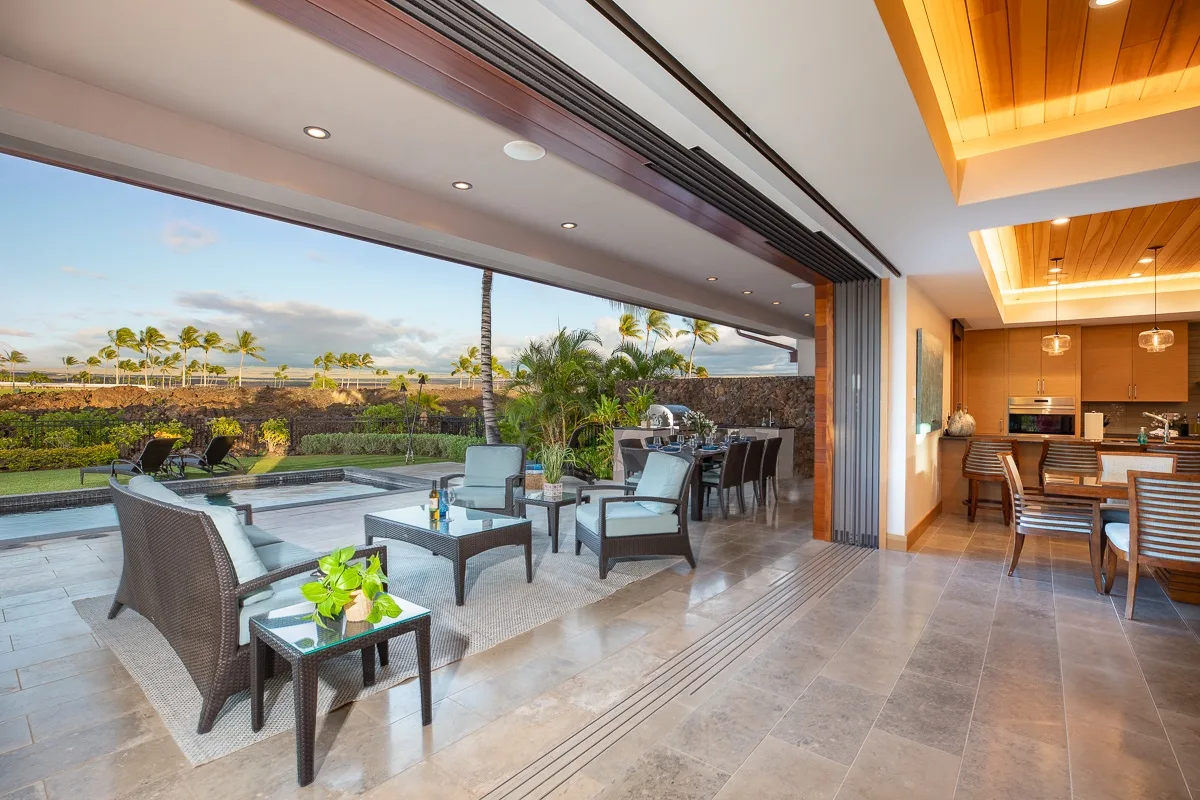 Un patio abierto con asientos junto a un comedor y una cocina.
