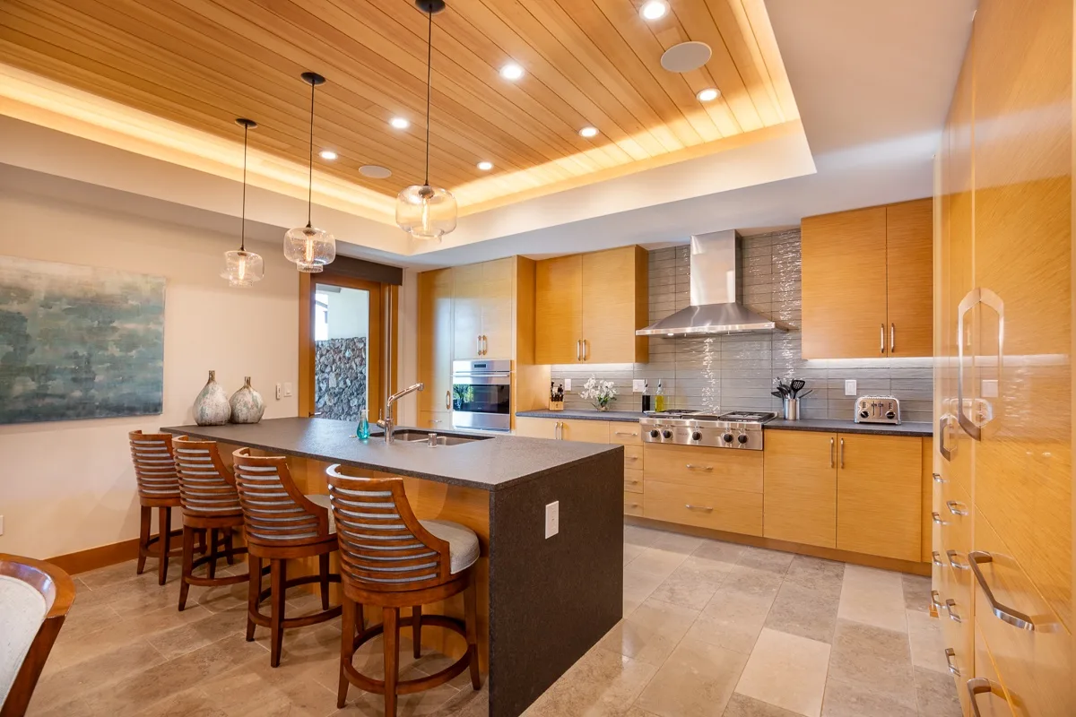 A modern kitchen with a central island and wooden cabinetry.