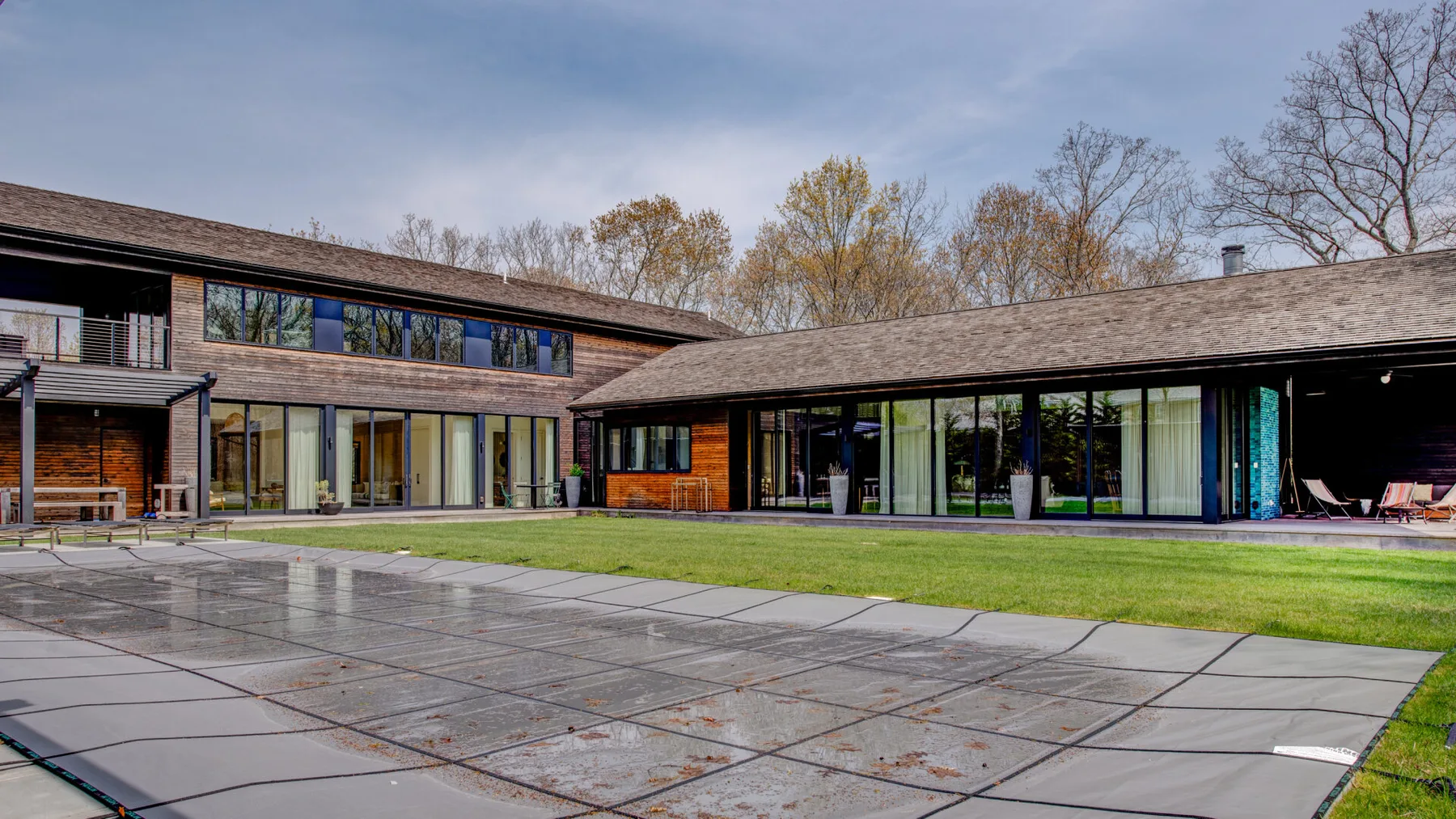 A modern building faces a paved courtyard and lawn.