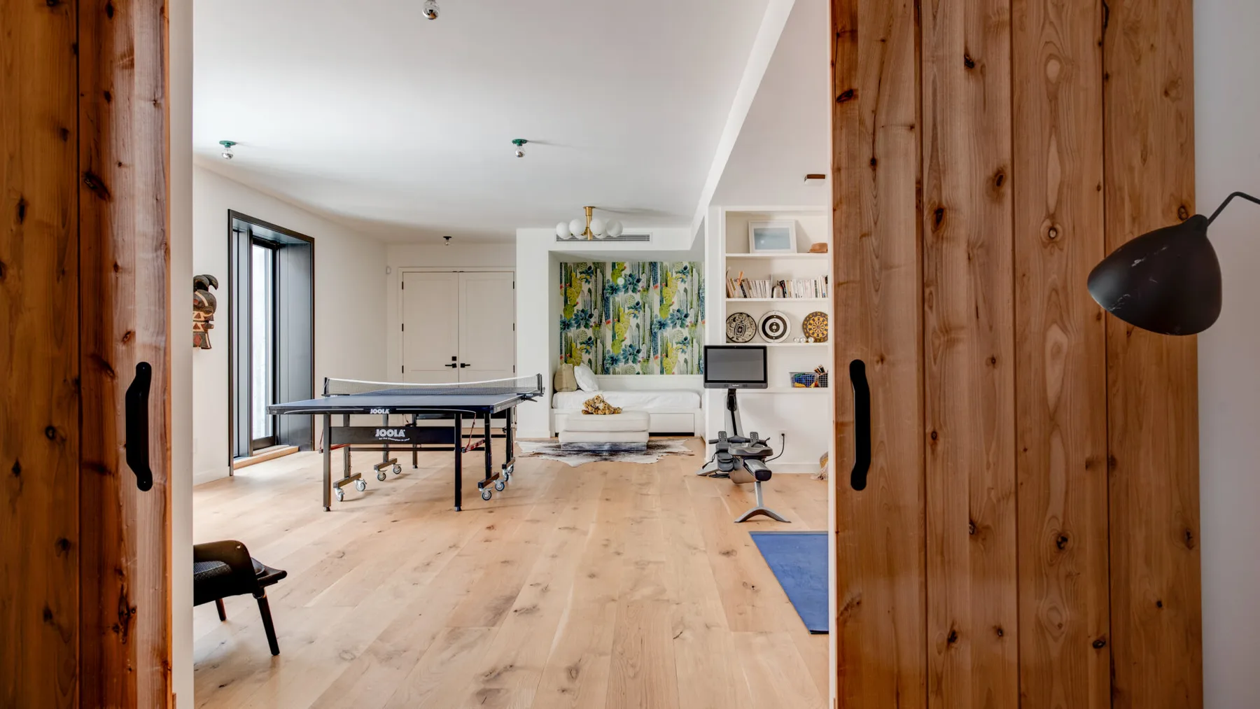 A bright living area with a table tennis table and seating.
