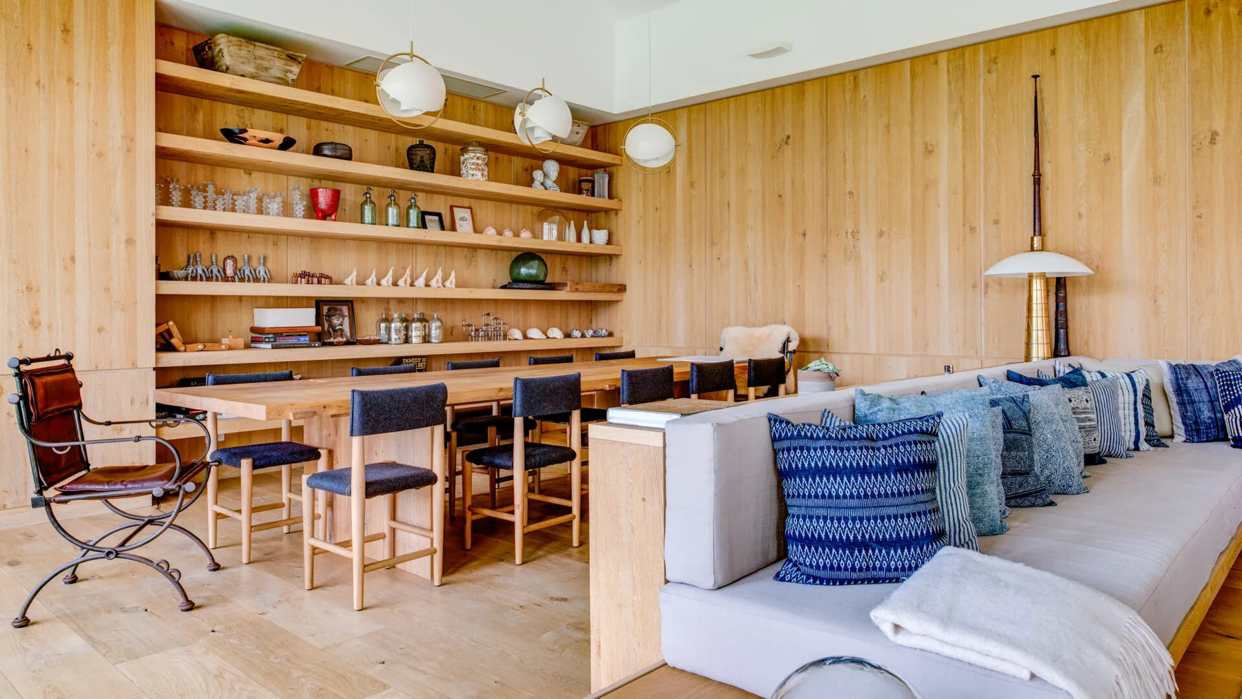 A wood-paneled lounge with a long counter, stools, and cushioned seating.