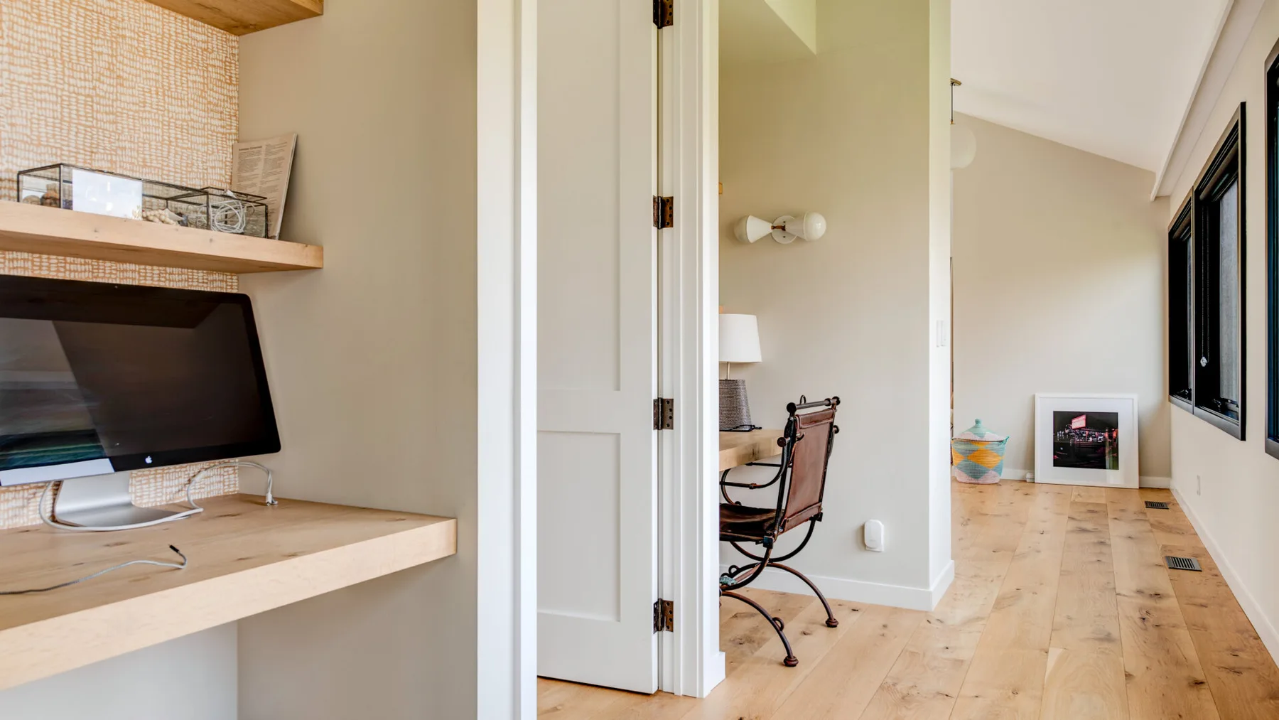 A bright interior hallway with a built-in desk and a work area.