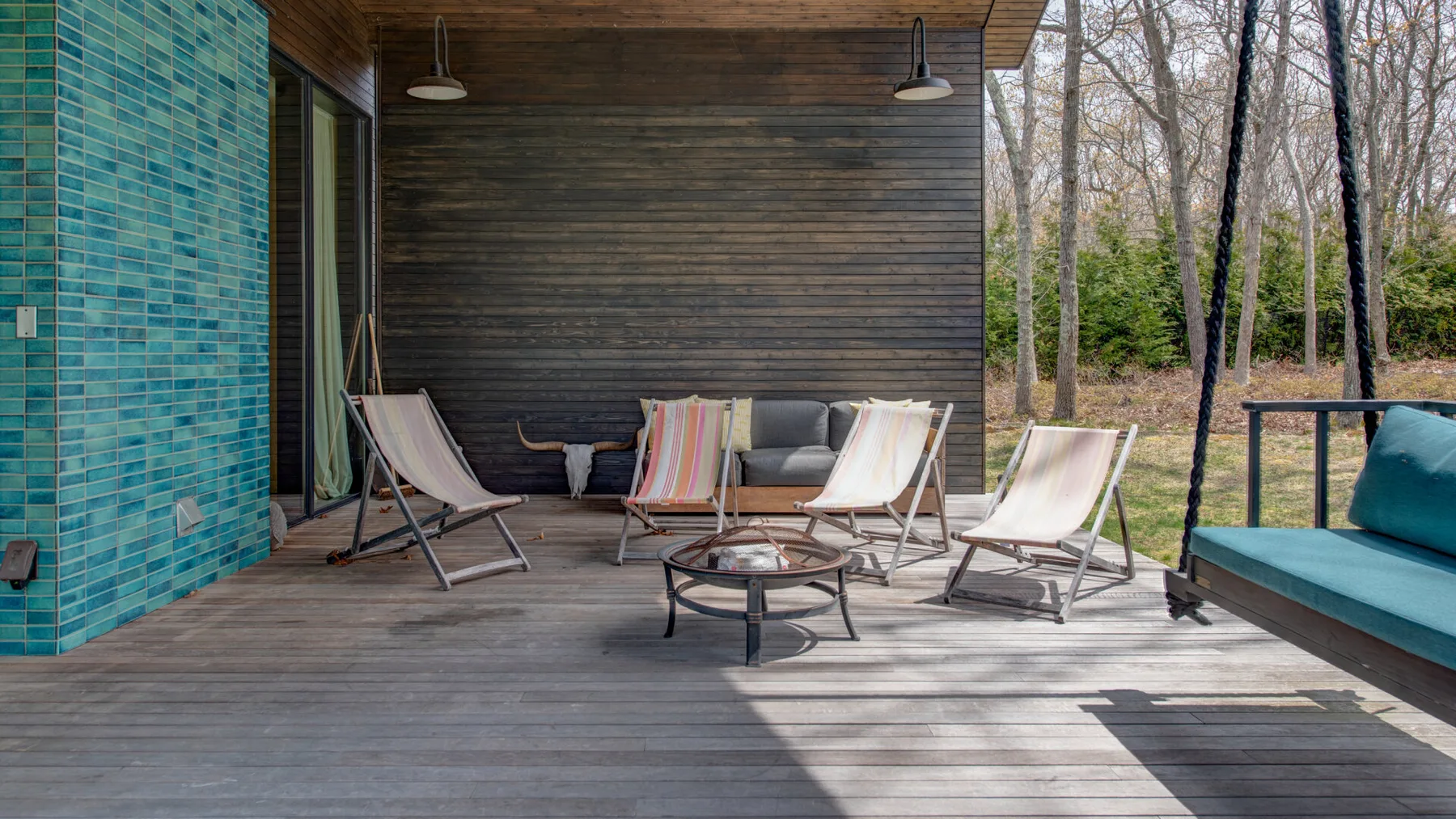 A covered outdoor seating area with lounge chairs and a low table.