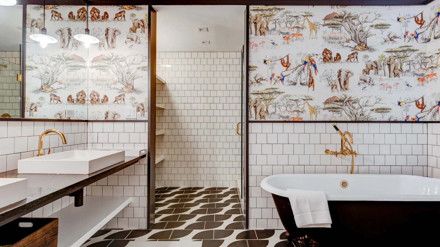 A tiled bathroom with a freestanding bathtub, vanity, and illustrated wall panels.