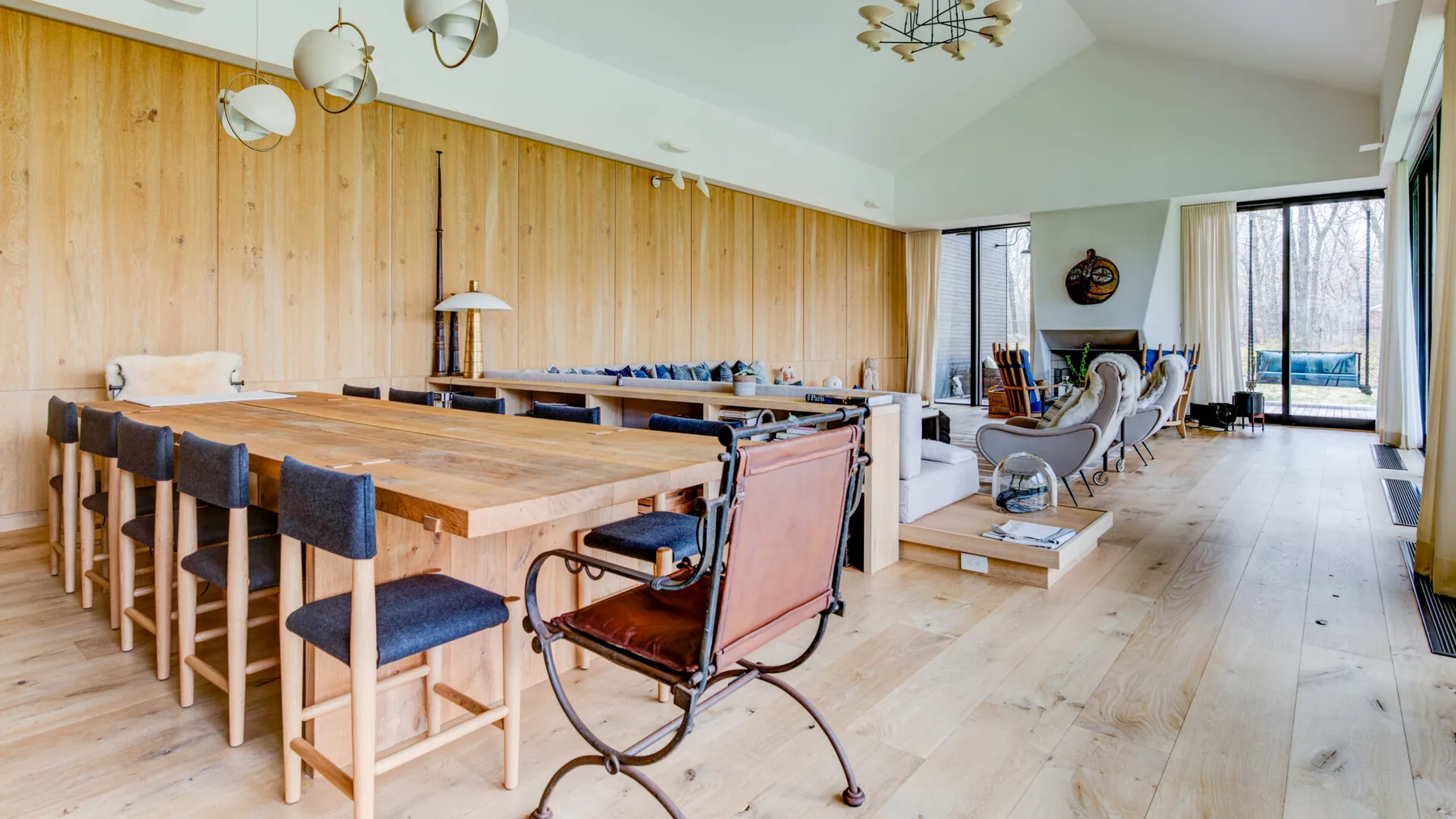 A spacious dining and living area with a long wooden table and seating.