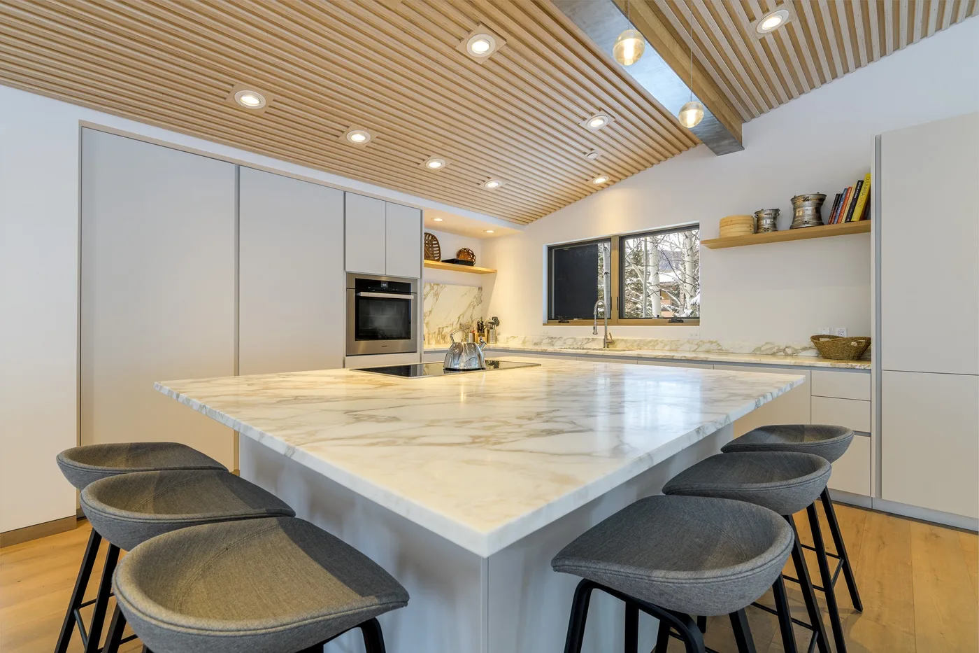 Una cocina moderna y luminosa destaca una gran isla con asientos.