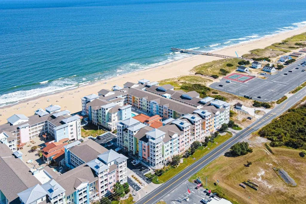 Vista aérea de edificios junto a la playa, el océano y una carretera costera.