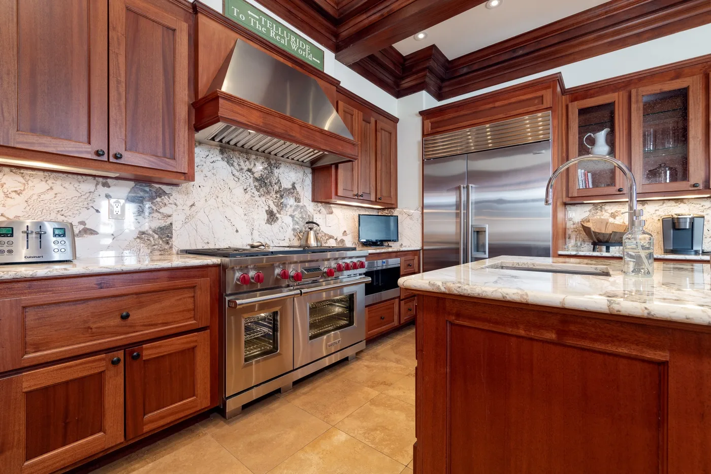 A spacious wood-cabinet kitchen with a large island and stainless-steel appliances.