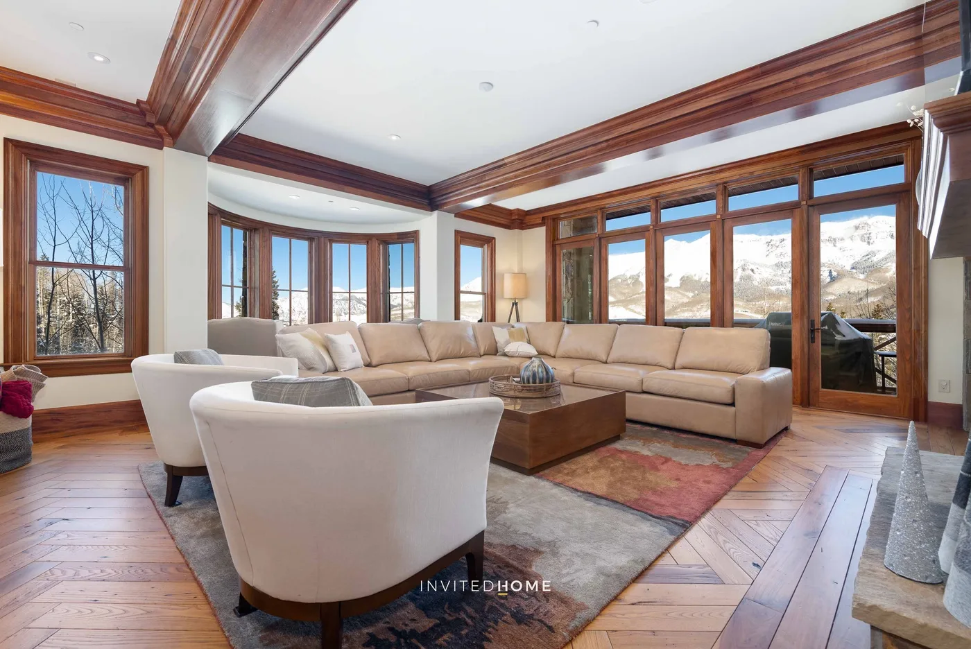 A living room with a sectional seating area beside large windows.