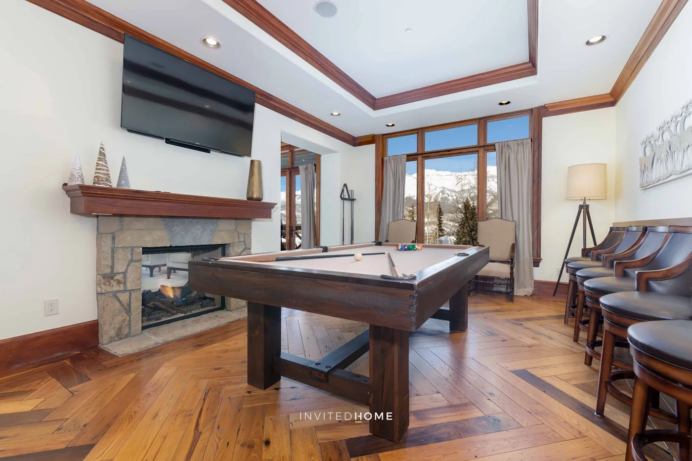 A game room with a pool table, fireplace, and seating.