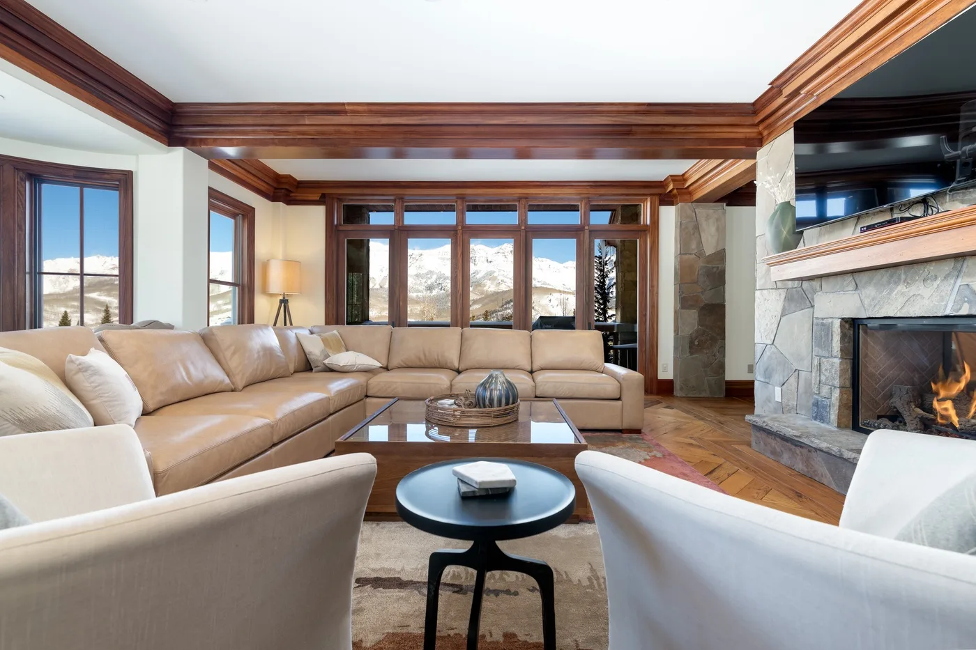 A living room with sectional seating, a coffee table, and a fireplace.