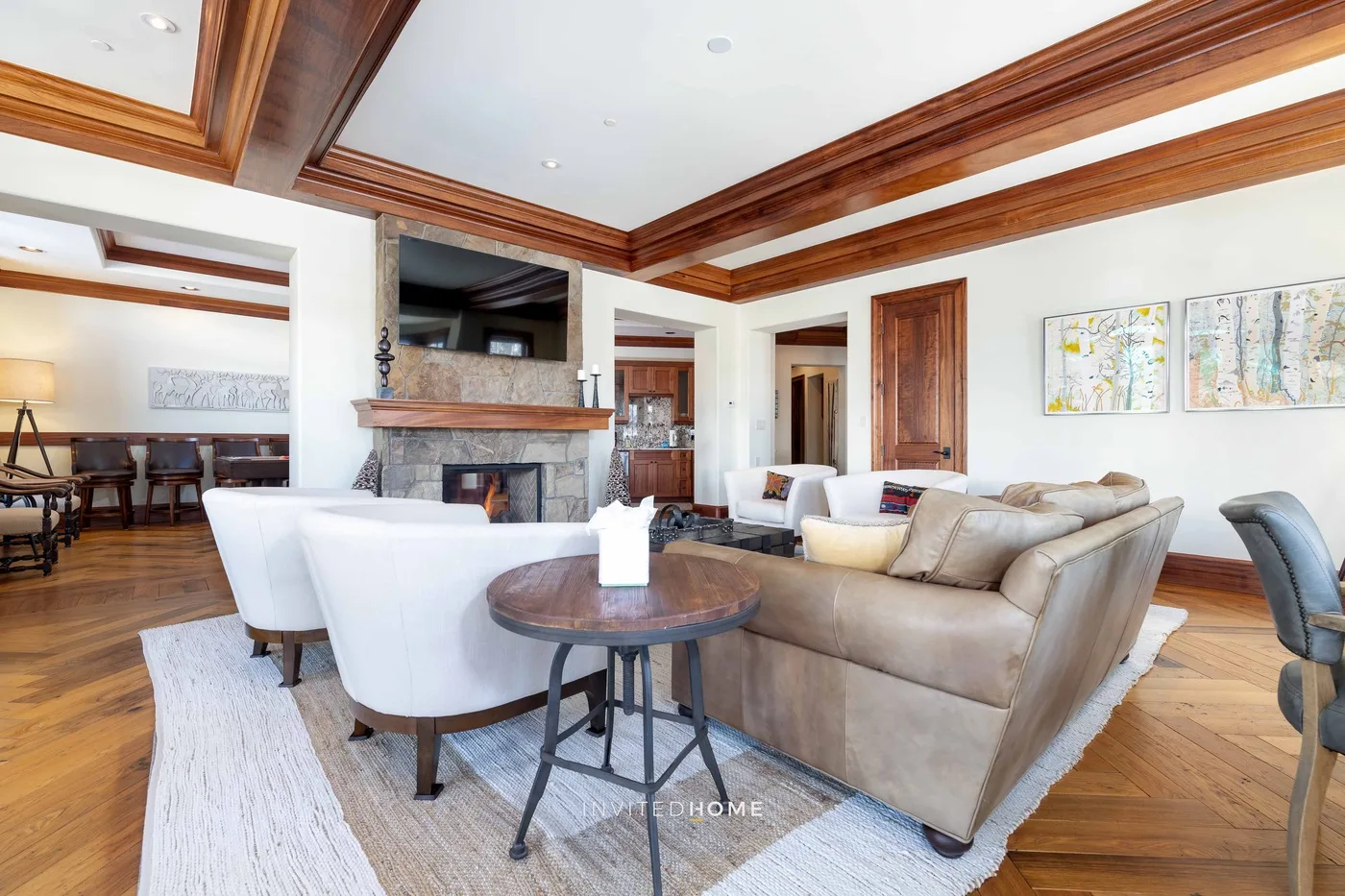 A spacious living room has seating around a fireplace, with a dining area beyond.