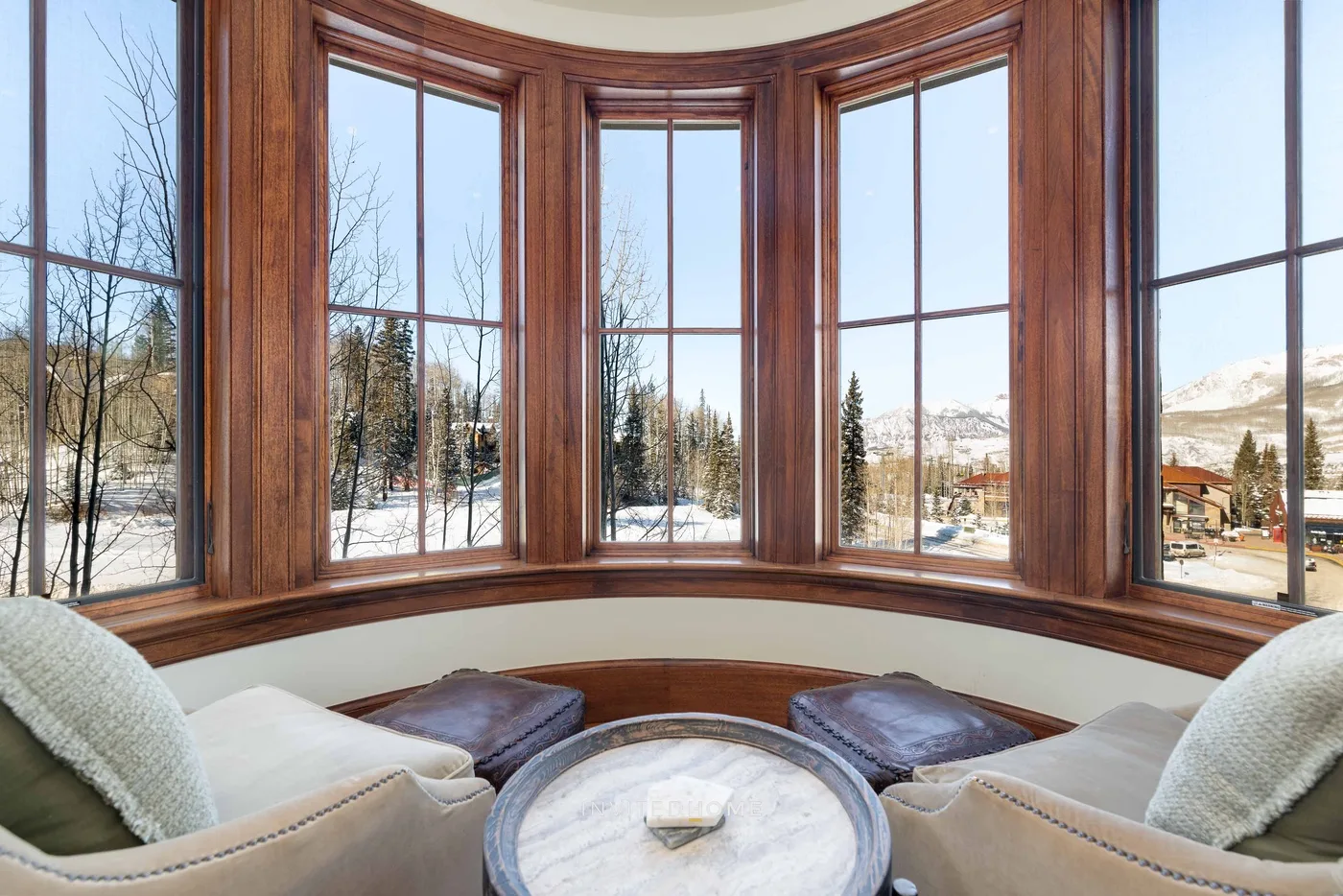A sitting area with large windows overlooks a snowy landscape.
