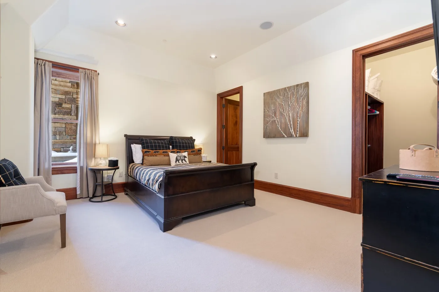 A bedroom with a bed, a window, and a framed wall picture.