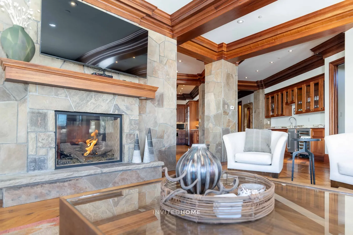 A living room with a stone fireplace, television, and seating.