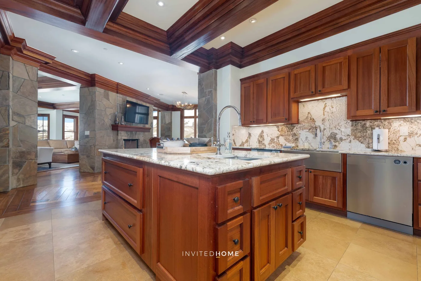 A spacious kitchen with a wood-paneled island and stone countertops.