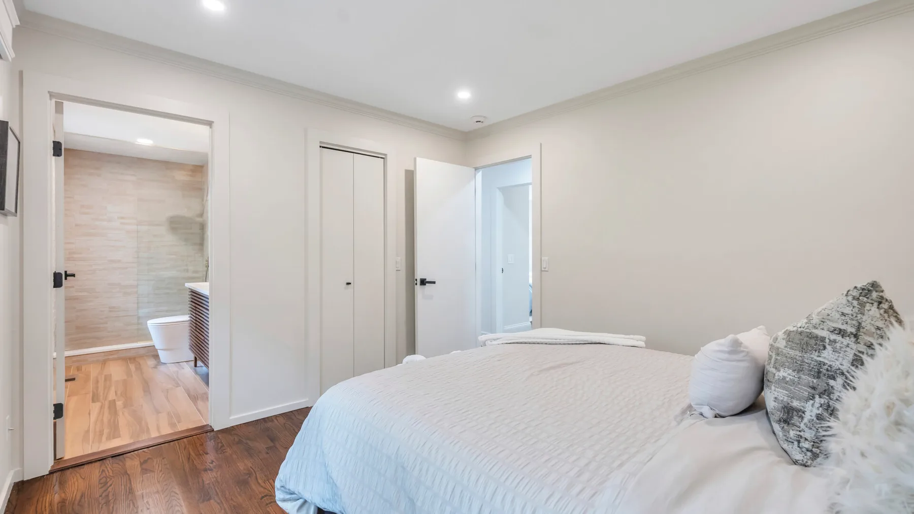 Un dormitorio luminoso con una cama y una puerta abierta.