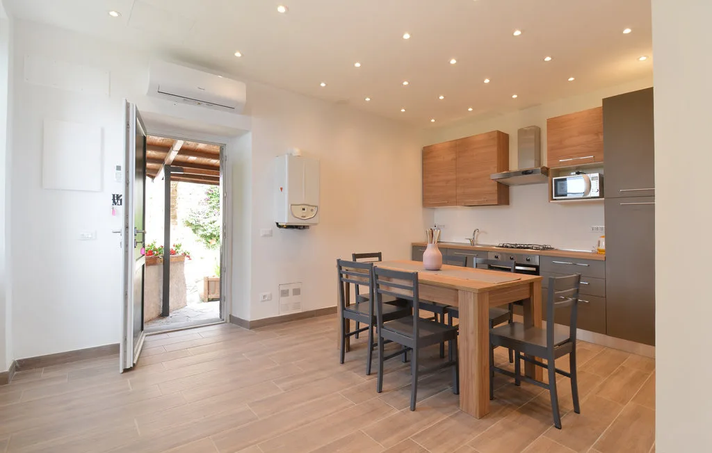 Una cocina y comedor luminosos con una mesa de madera y sillas.