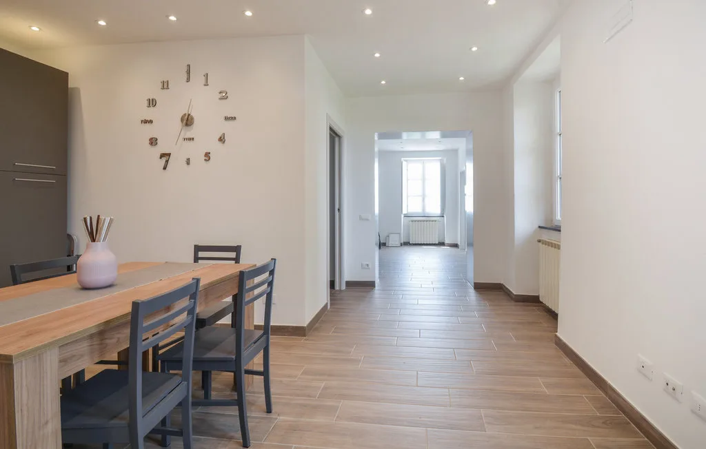 A dining area opens into a bright hallway with a window at the far end.